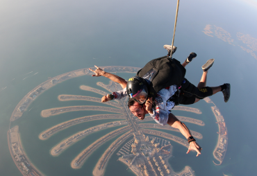 Skydivers in tandem leap over the iconic Palm Jumeirah in Dubai.