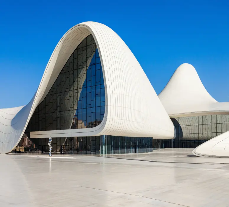 Modern curved architecture of Heydar Aliyev Center with reflective glass windows in Baku.