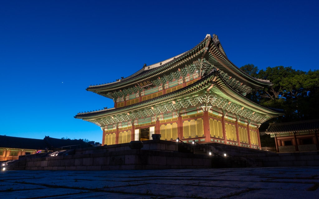 View of Changdeokgung Palace with traditional Korean architecture and autumn colors, featured in a South Korea tour package exploring Seoul